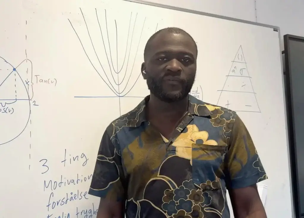 Kofi D. Mensah, matematiklærer og stifter af NemMat, ved en tavle med matematik